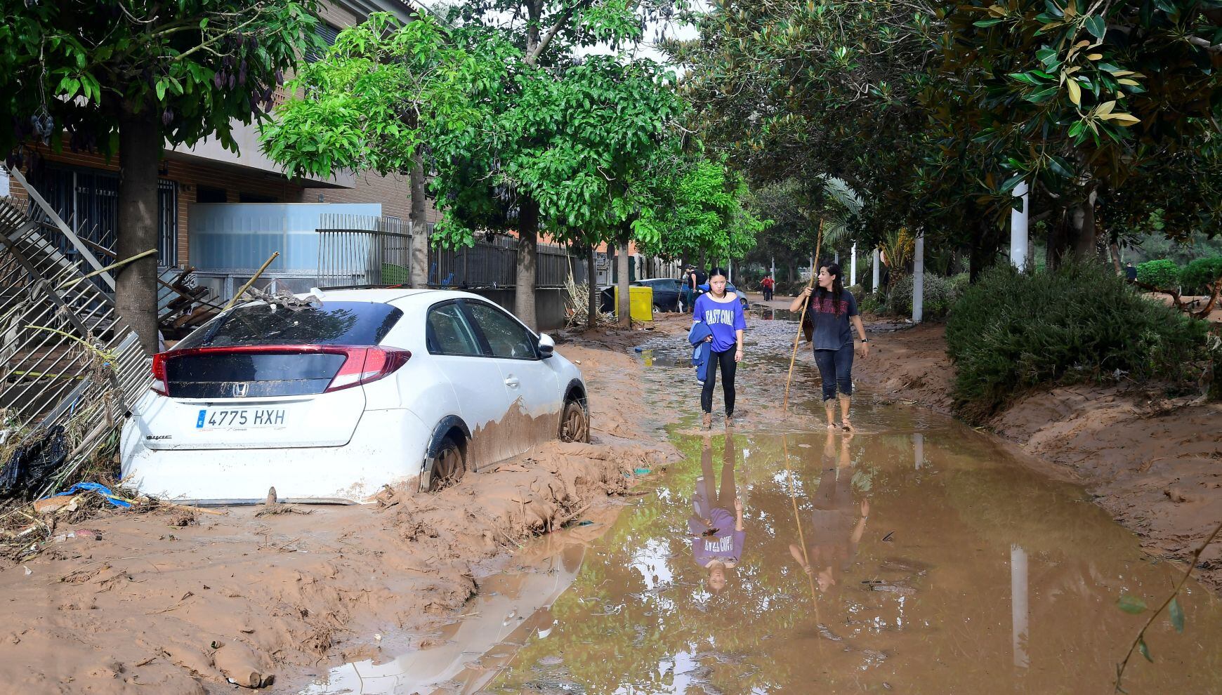 Los residentes caminan por una calle cubierta de barro en una zona inundada en Picanya, cerca de Valencia, este de España, el 30 de octubre de 2024 (Foto: José Jordán / AFP)