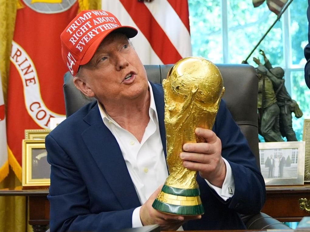 ARCHIVO - Foto del 22 de agosto del 2025, el presidente Donald Trump sostiene el trofeo al campeón de la Copa Mundial en una reunión en la Oficina Oval con el presidente de la FIFA Gianni Infantino. (AP Foto/Jacquelyn Martin, Archivo)