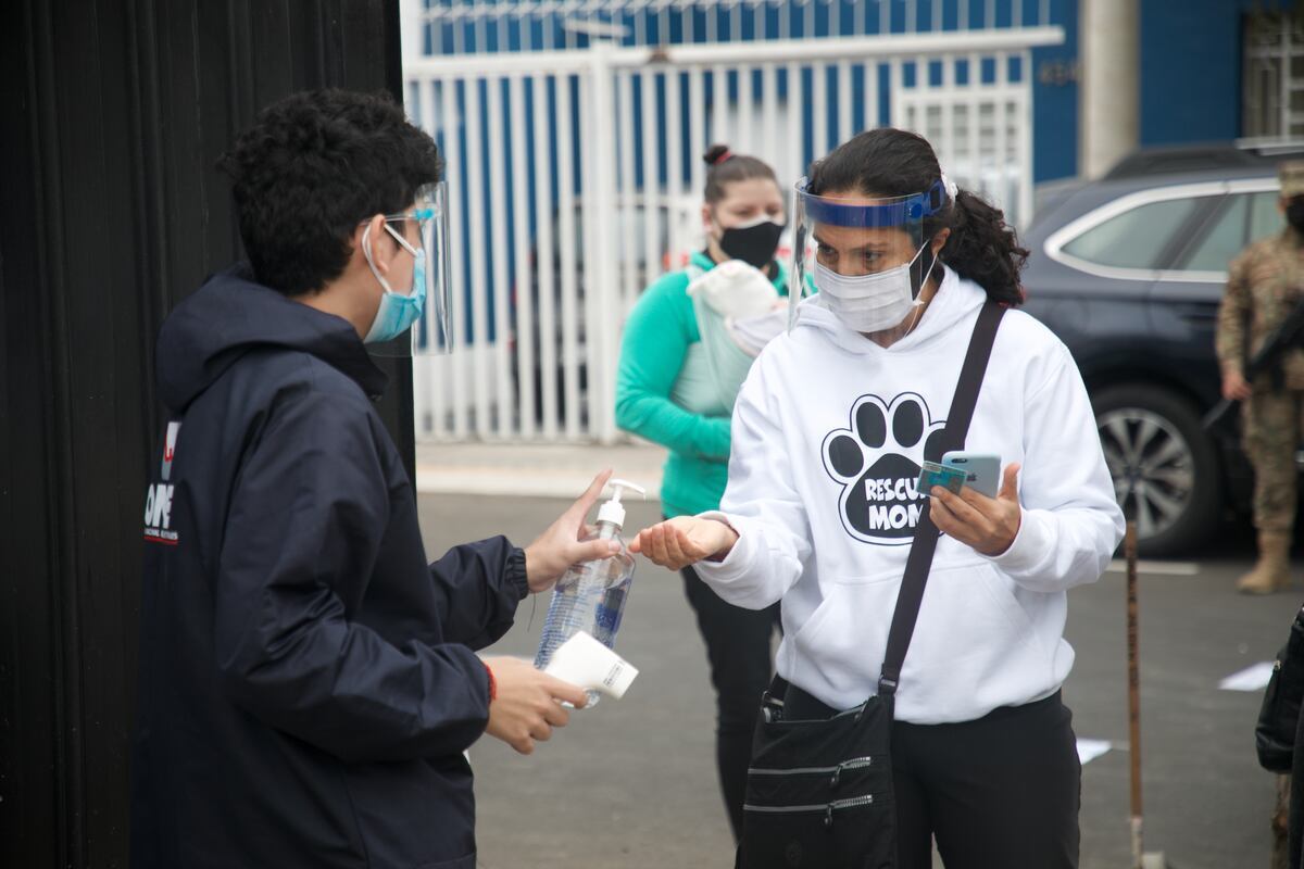 Persona desinfectando sus manos antes de ingresar al centro de votación, como parte de las medidas para prevenir contagios del COVID-19 (Foto: GEC)