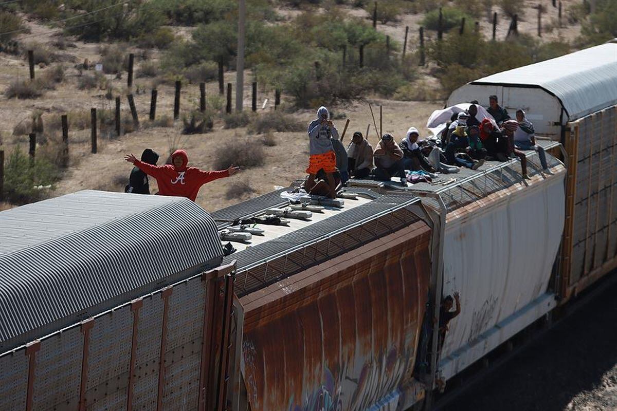 “En la noche hay frío y en el día calor. Y hambre también porque uno no se puede bajar del tren. Hay personas que se paran y nos lanzan cosas y ahí podemos agarrar que si un agua o un pan”, relató José. (Foto: EFE)