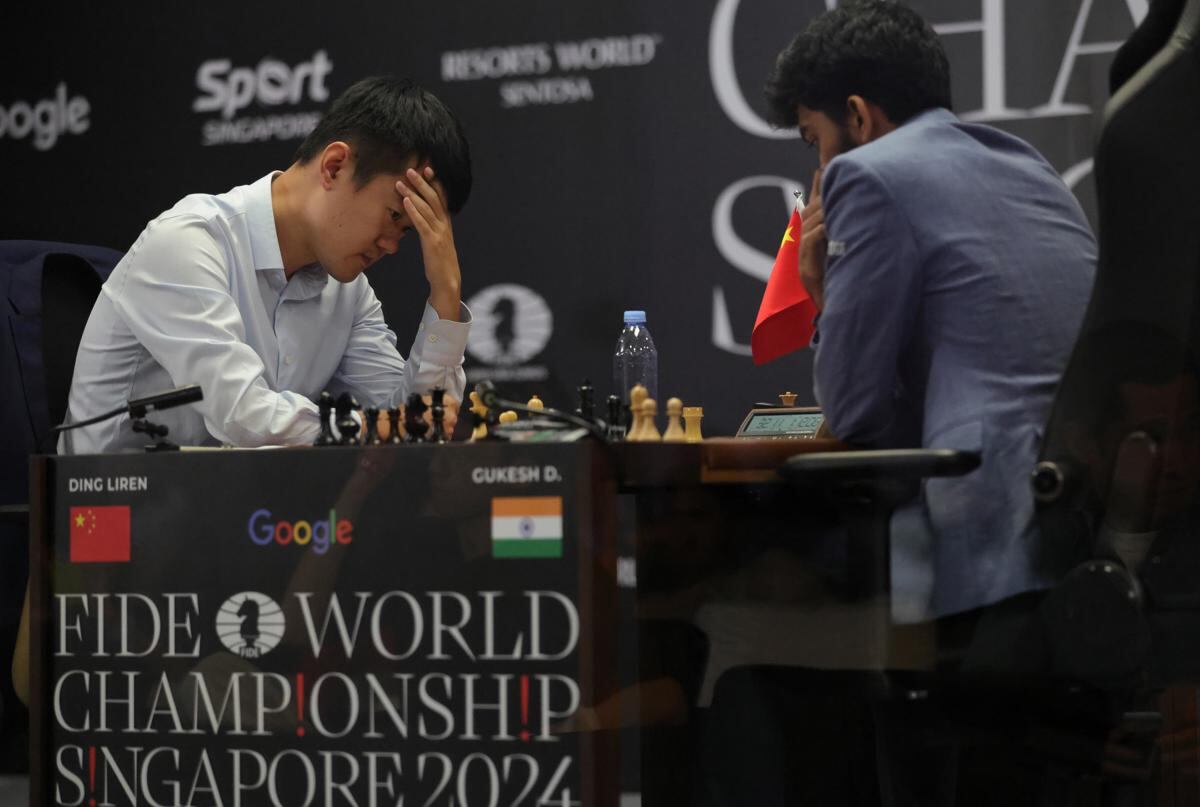El gran maestro de ajedrez Ding Liren (I) de China reacciona durante la partida 14 contra Gukesh Dommaraju de India en el Campeonato Mundial de Ajedrez de la FIDE en Singapur, el 12 de diciembre de 2024. Gukesh Dommaraju se convirtió en el campeón mundial de ajedrez más joven de la historia al vencer a Ding Liren en el campeonato al mejor de 14 partidas. (Singapur, Singapur) EFE/EPA/HOW HWEE YOUNG