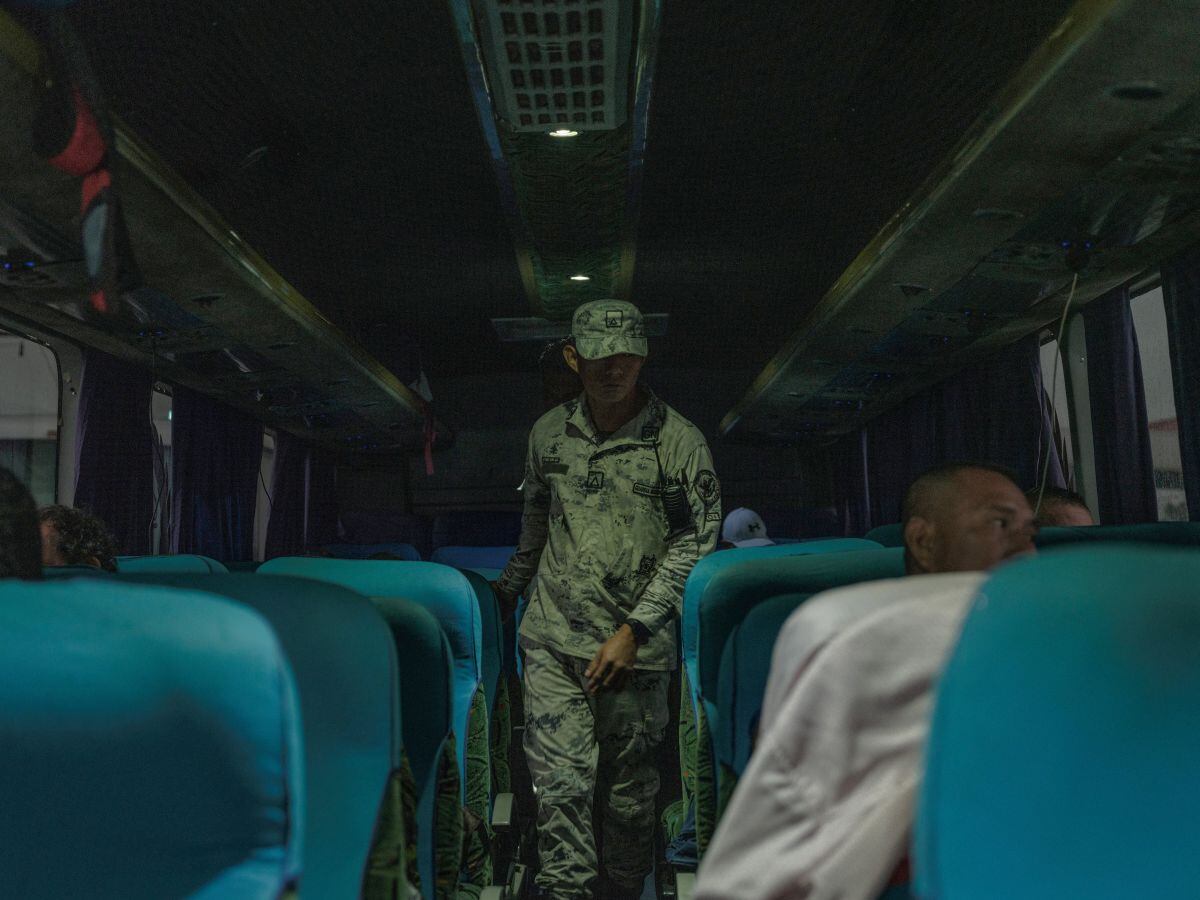 Un miembro de la Guardia Nacional acompaña a un oficial del Instituto de Migración a revisar la documentación de pasajeros de autobús en La Venta. Fotógrafo: Alejandro Cegarra /Bloomberg