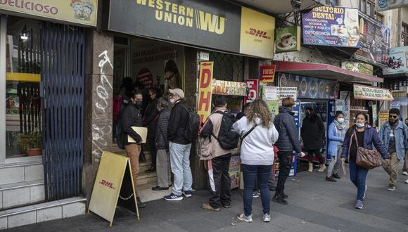 Los clientes esperan en fila afuera de un local de Western Union en La Paz, Bolivia, el 30 de marzo de 2023.
