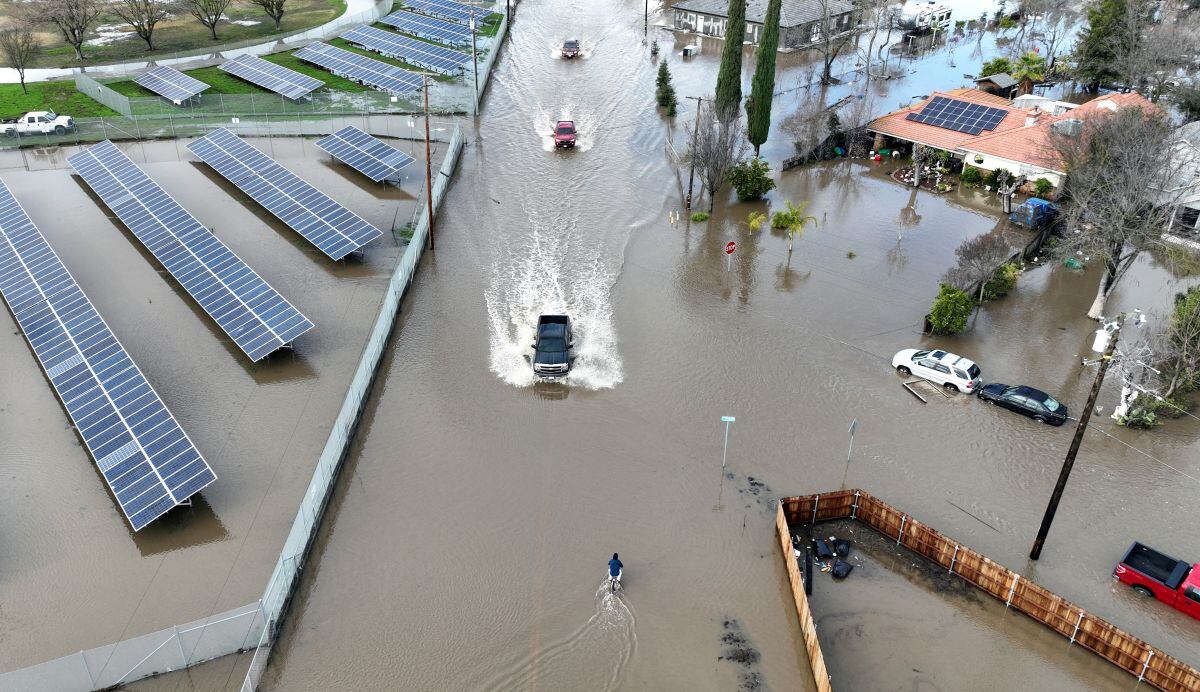 Esta vista aérea muestra automóviles conduciendo por una carretera inundada en Planada, California, mientras un "río atmosférico" continúa el 10 de enero de 2023 (Foto: Josh Edelson / AFP)