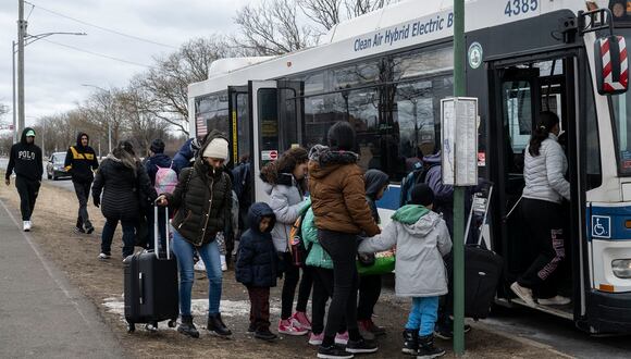 Migrantes recién llegados suben a un autobús frente al refugio Floyd Bennett Field, el 21 de febrero de 2024, en el distrito de Brooklyn de Nueva York. (Foto de ANGELA WEISS / AFP)