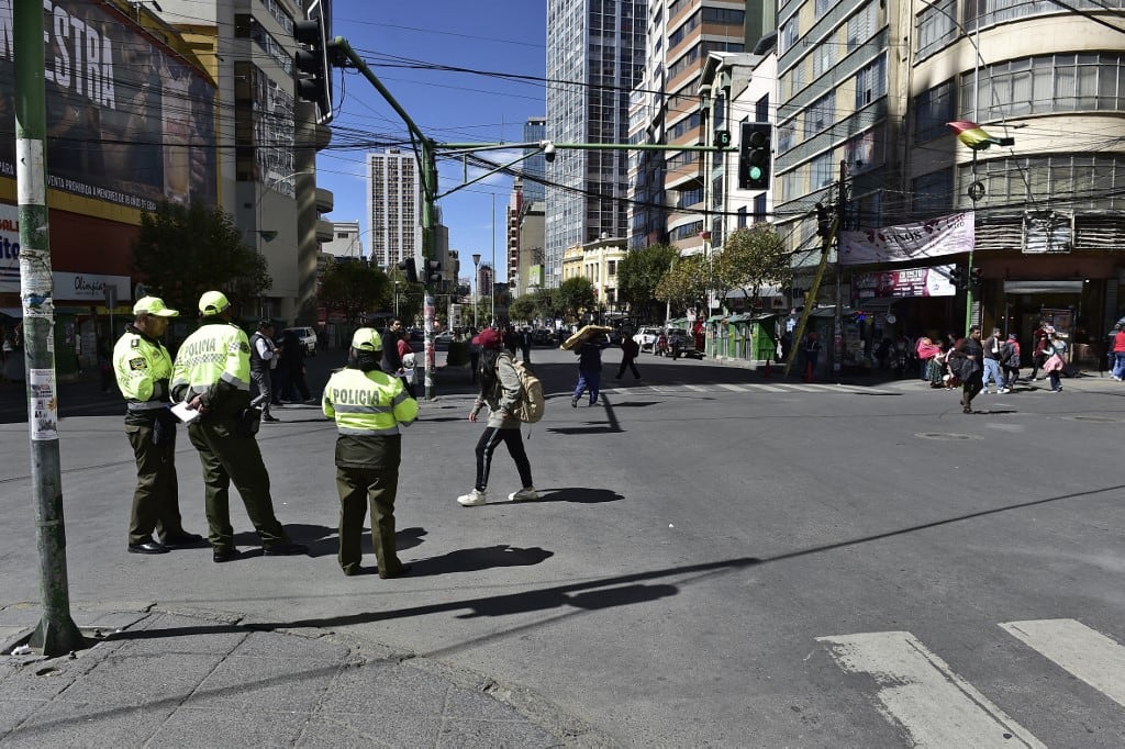 Policías montan guardia en una calle casi vacía durante una huelga de transporte de 24 horas convocada por la Confederación Boliviana de Conductores en protesta por la mala calidad del petróleo, en La Paz, el 5 de mayo de 2026. (Foto de Jorge Bernal / AFP)