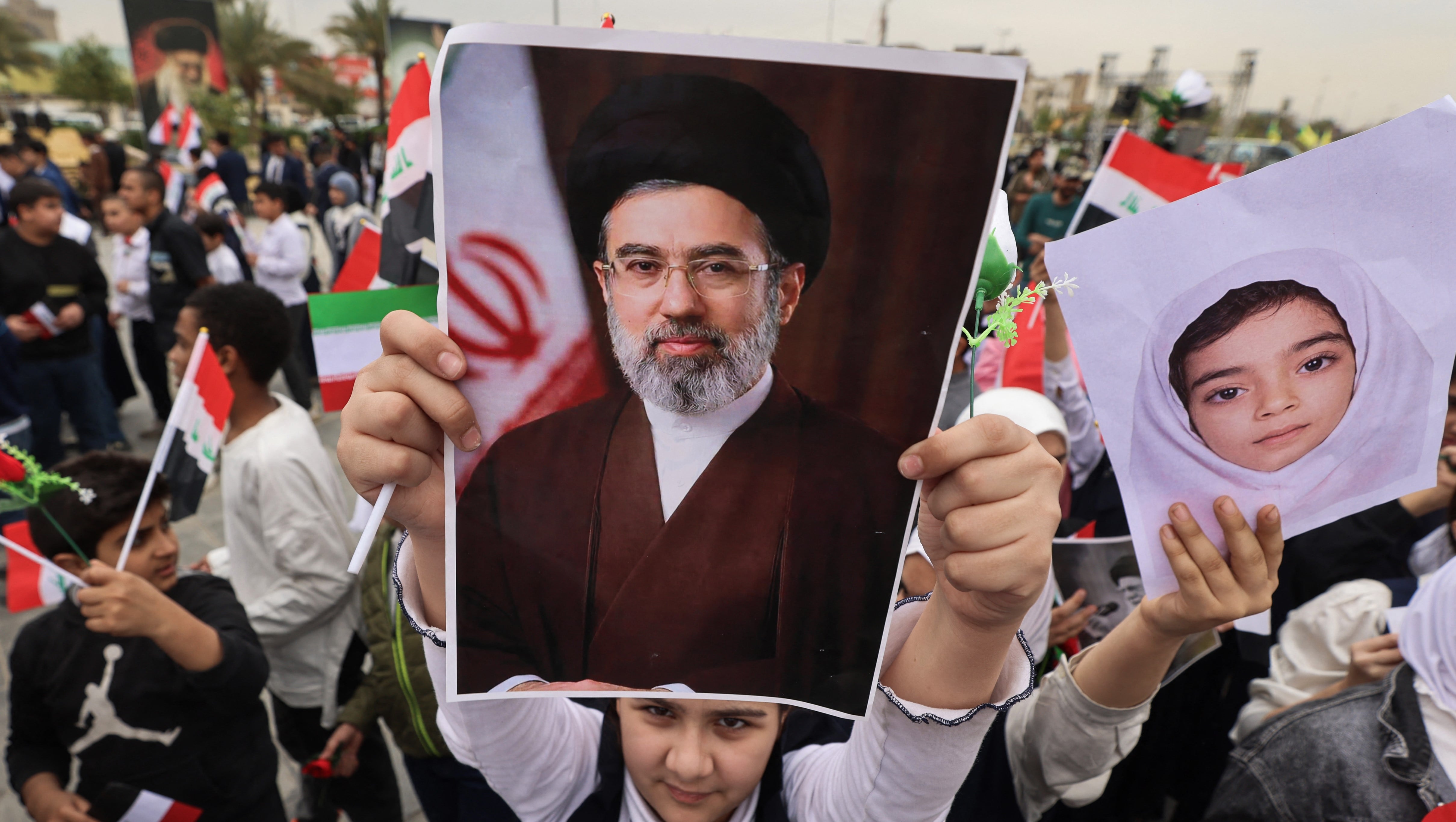 Una colegiala sostiene un cartel del nuevo líder supremo de Irán, Mojtaba Jamenei, durante una manifestación contra Estados Unidos e Israel en Bagdad el 12 de marzo de 2026. (Foto de AHMAD AL-RUBAYE / AFP).