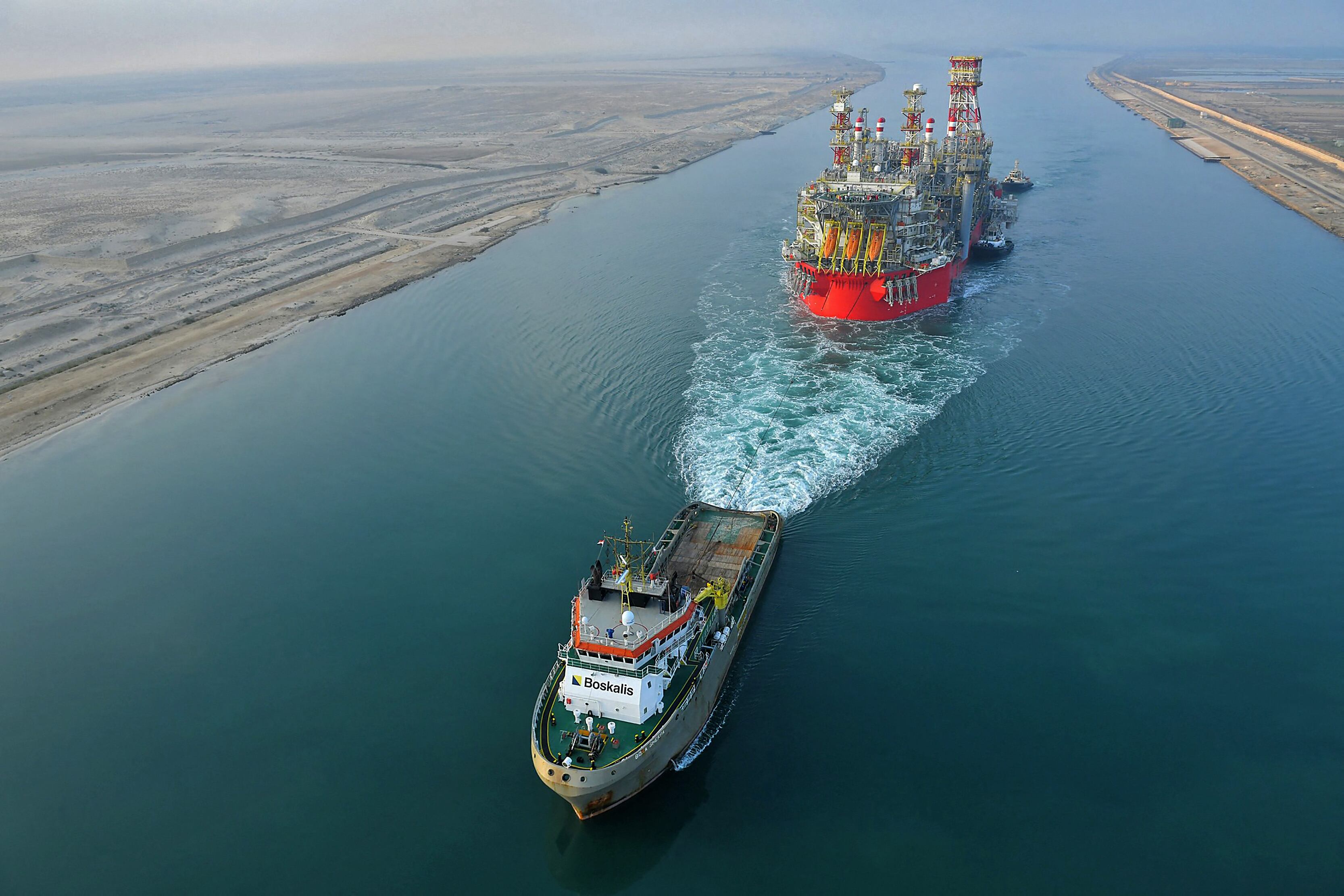 Una imagen fechada el 3 de junio de 2022, y obtenida de la Autoridad del Canal de Suez de Egipto, muestra un remolcador tirando de un barco de almacenamiento y descarga de producción flotante (FPSO) de Energean a lo largo del Canal de Suez de Egipto. (Foto de varias fuentes / AFP)