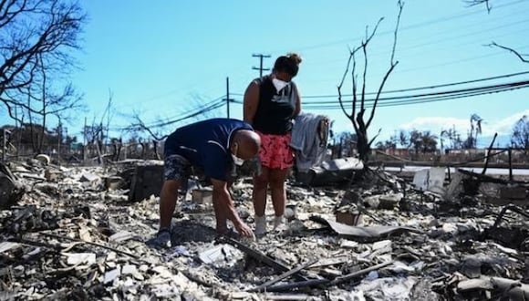 Davilynn Severson y Hano Ganer buscan pertenencias entre las cenizas de la casa de su familia después de un incendio forestal en Lahaina, en el oeste de Maui, Hawái. (Foto: AFP)
