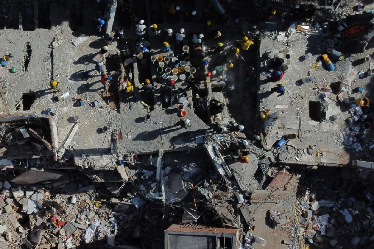 Voluntarios y rescatistas utilizan cubos para retirar los escombros de un edificio derrumbado un día después de un terremoto que remeció Cali, Colombia, el 11 de agosto de 2026. (Foto: Santiago Saldarriaga/AP)