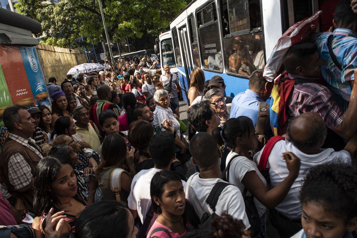 Pasajeros intentan abordar un autobús público durante un apagón en Caracas, en marzo de 2019. Fuente: Bloomberg