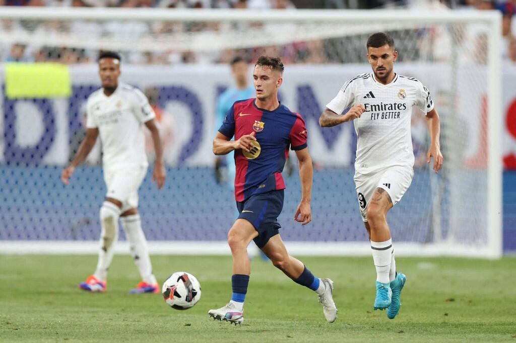 Barcelona's Spanish midfielder #30 Marc Casado (L) vies for the ball with Real Madrid's Spanish midfielder #19 Dani Ceballos (R) during the pre-season club friendly football match between Real Madrid and FC Barcelona at MetLife Stadium, in East Rutherford, New Jersey on August 3, 2024. (Photo by Charly TRIBALLEAU / AFP)
