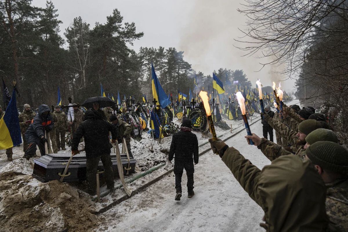 Sepultureros bajan un féretro a una tumba durante el funeral de Sviatoslav Romanchuk, un soldado ucraniano, en el cementerio de Kiev, Ucrania. (AP Foto/Evgeniy Maloletka)
