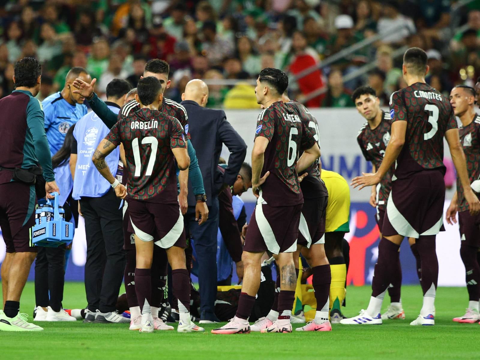 Los jugadores y el personal de México se reúnen alrededor del mediocampista Edson Álvarez, quien resultó herido durante el partido de fútbol del grupo B del torneo Copa América Conmebol 2024 entre México y Jamaica en el NRG Stadium de Houston, Texas, el 22 de junio de 2024. (Foto de Aric Becker / AFP )