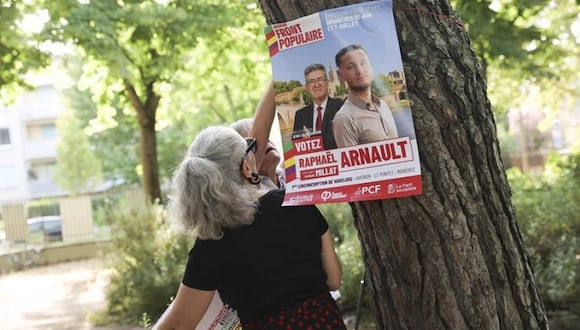 Una mujer coloca un cartel electoral en Avignon (Francia). EFE/EPA/Teresa Suarez