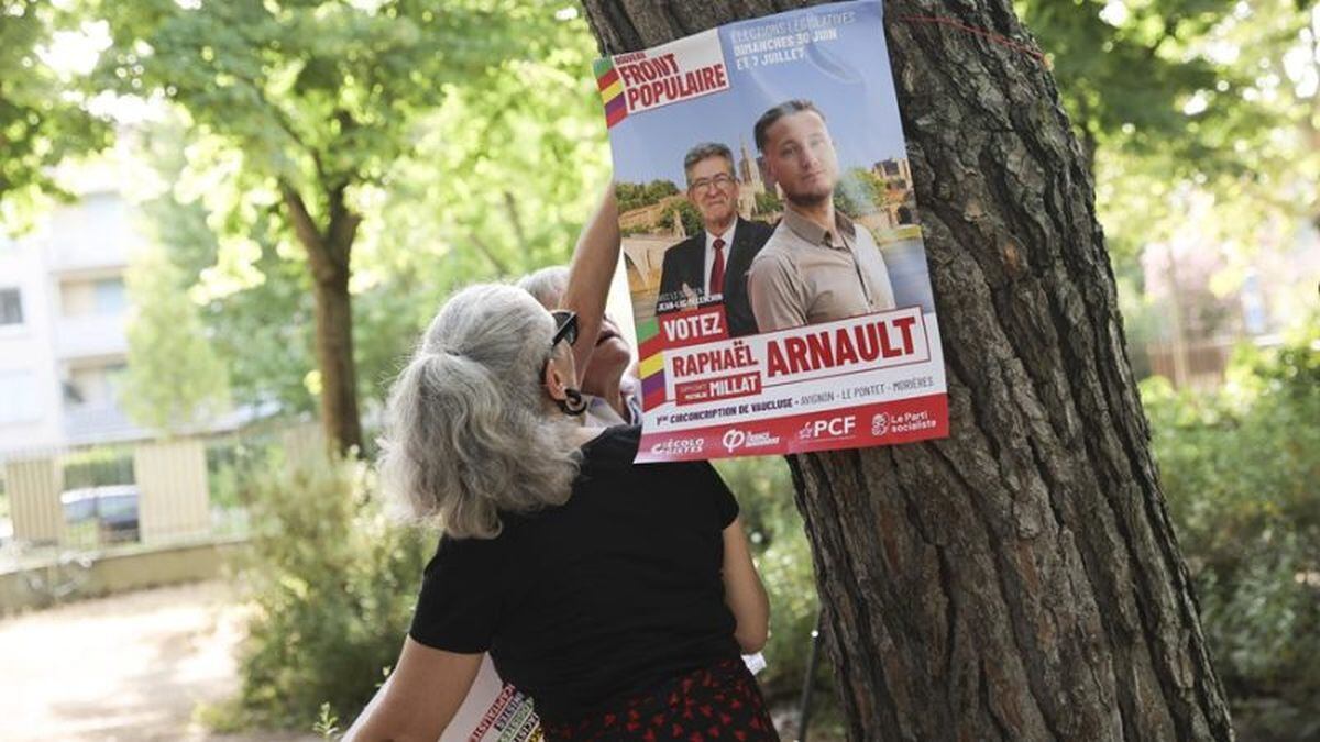 Una mujer coloca un cartel electoral en Avignon (Francia). EFE/EPA/Teresa Suarez