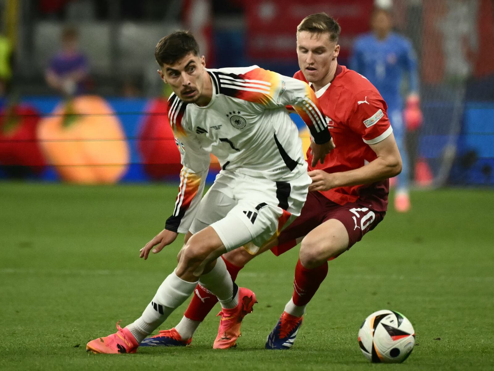El delantero alemán #07 Kai Havertz y el centrocampista suizo #20 Michel Aebischer compiten por el balón durante el partido de fútbol del Grupo A de la UEFA Euro 2024 entre Suiza y Alemania en el Frankfurt Arena de Fráncfort del Meno el 23 de junio de 2024. | Crédito: Angelos Tzortzinis / AFP