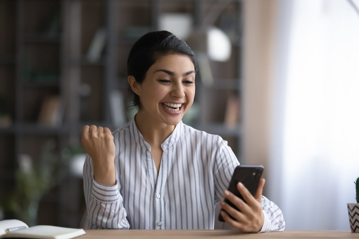 Una usuaria feliz por las cifras que ve en su celular (Foto: Shutterstock)
