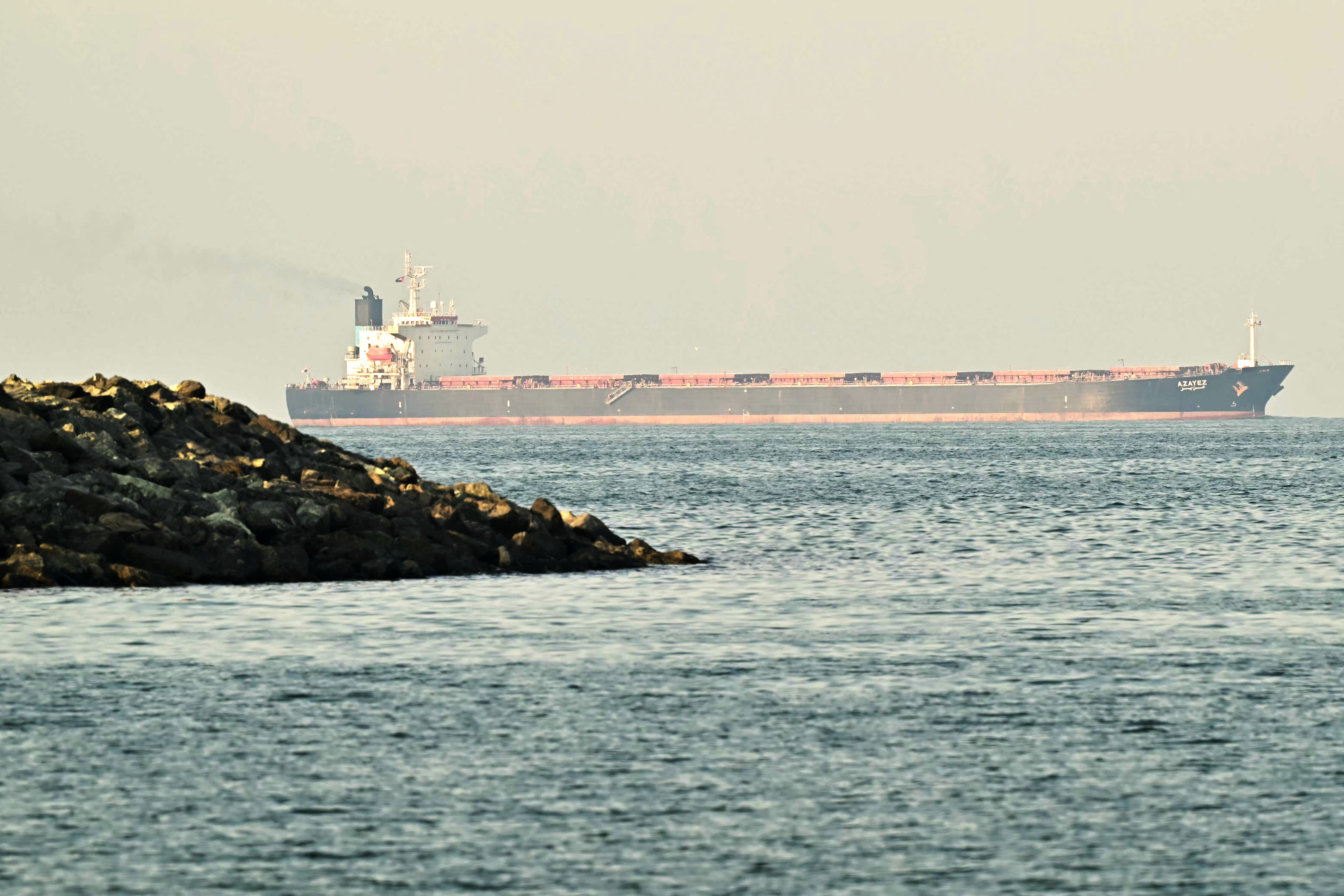 Un buque de carga se observa frente a la costa de Fujairah, en el estrecho de Ormuz, el 25 de febrero de 2026. (Foto de Giuseppe CACACE / AFP).