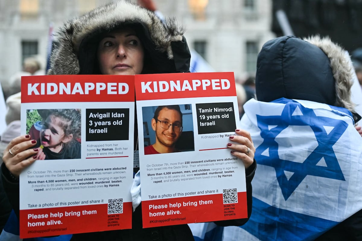 Un manifestante muestra fotografías de personas tomadas como rehenes por el grupo militante palestino Hamás en Gaza. (Foto de JUSTIN TALLIS / AFP)