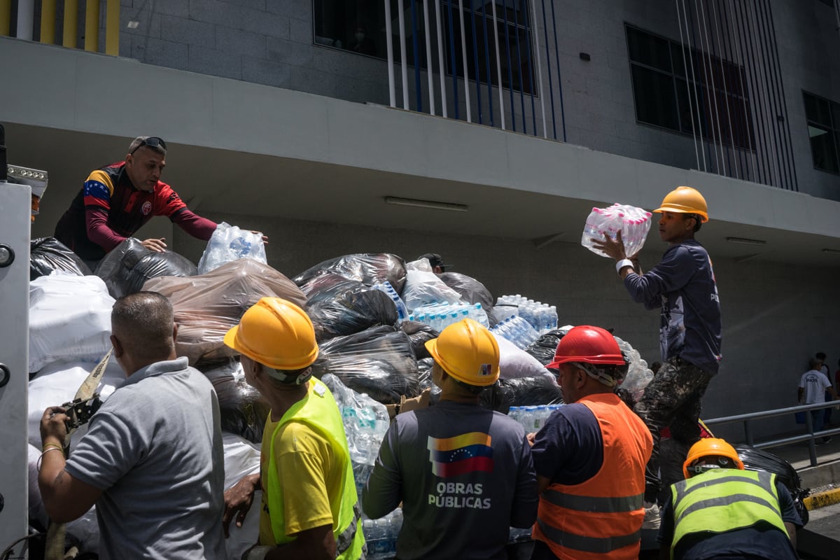 Personas cargan paquetes con donaciones, en el hospital Domingo Luciani de Petare de Caracas, Venezuela, el 26 de junio de 2026. (Boris Vergara / EFE)