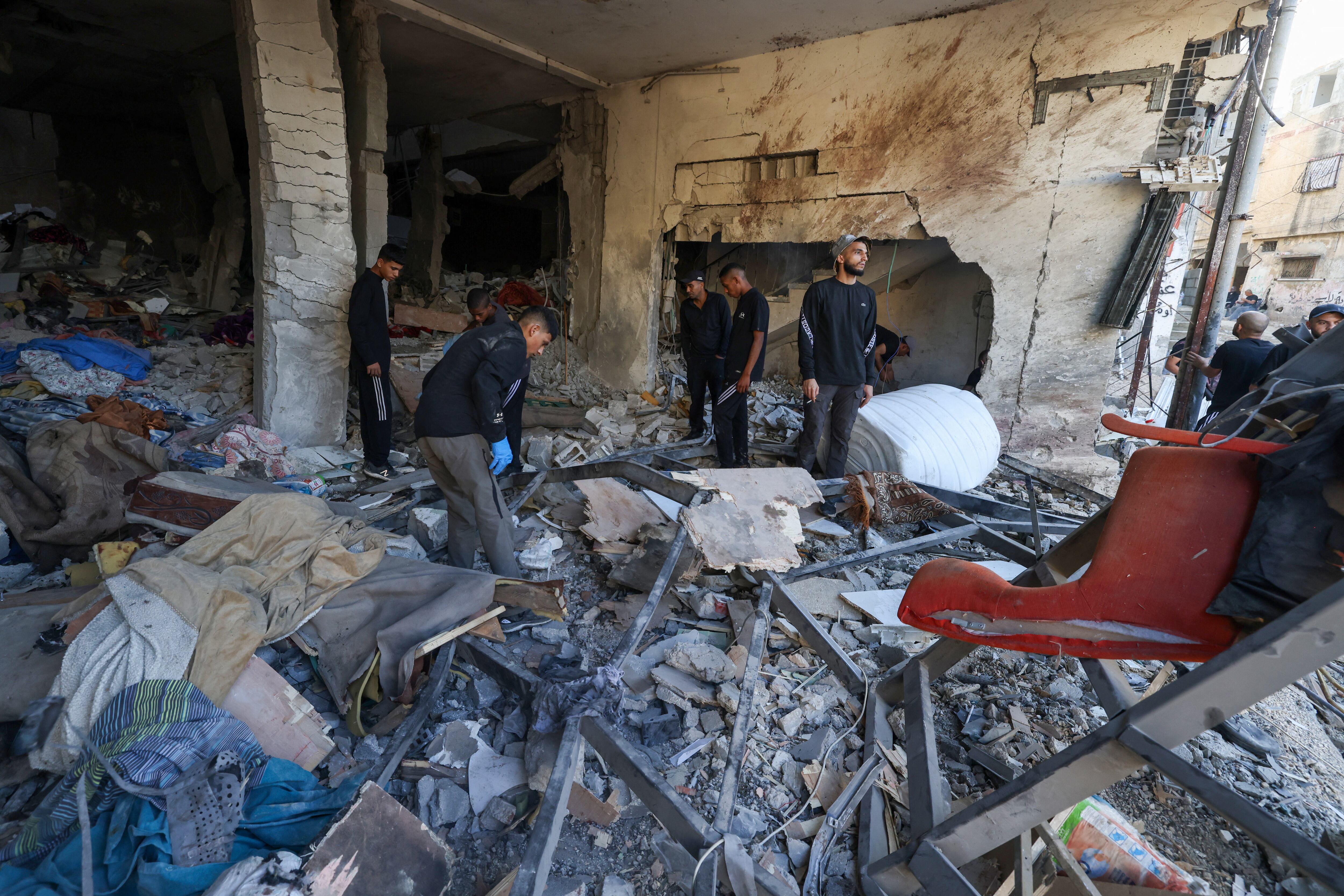 Palestinos inspeccionan los daños en el lugar de un ataque aéreo israelí nocturno en el campo de refugiados de Tulkarem, en el norte de Cisjordania ocupada, el 4 de octubre de 2024. (Foto de JAAFAR ASHTIYEH / AFP)