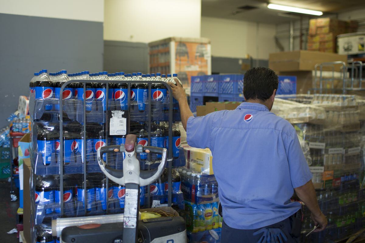 Un trabajador descarga palés de refrescos de PepsiCo Inc. dentro del área de almacenamiento de una tienda de comestibles en Phoenix, Arizona, EE.UU., el jueves 6 de julio de 2017. Fotógrafo: Caitlin O'Hara/Bloomberg