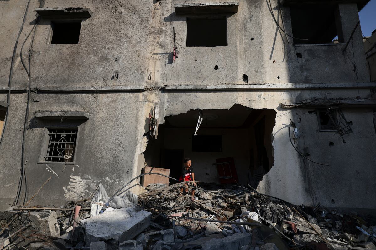 Un niño palestino observa desde un edificio gravemente dañado en la ciudad de Gaza, tras un alto el fuego entre Israel y militantes palestinos. (Foto de Mahmud HAMS / AFP)