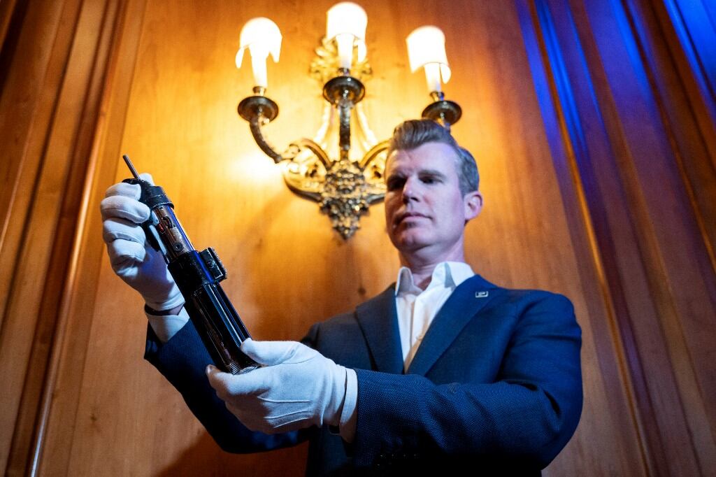 Un miembro del personal sostiene el sable de luz del personaje Darth Vader de las películas Star Wars: El Imperio Contraataca y El Retorno del Jedi durante una vista previa para la prensa de la utilería cinematográfica que se subastará en Londres el 6 de agosto de 2025. La subasta está prevista para septiembre de 2025 en Los Ángeles. (Foto de Niklas HALLE'N / AFP)