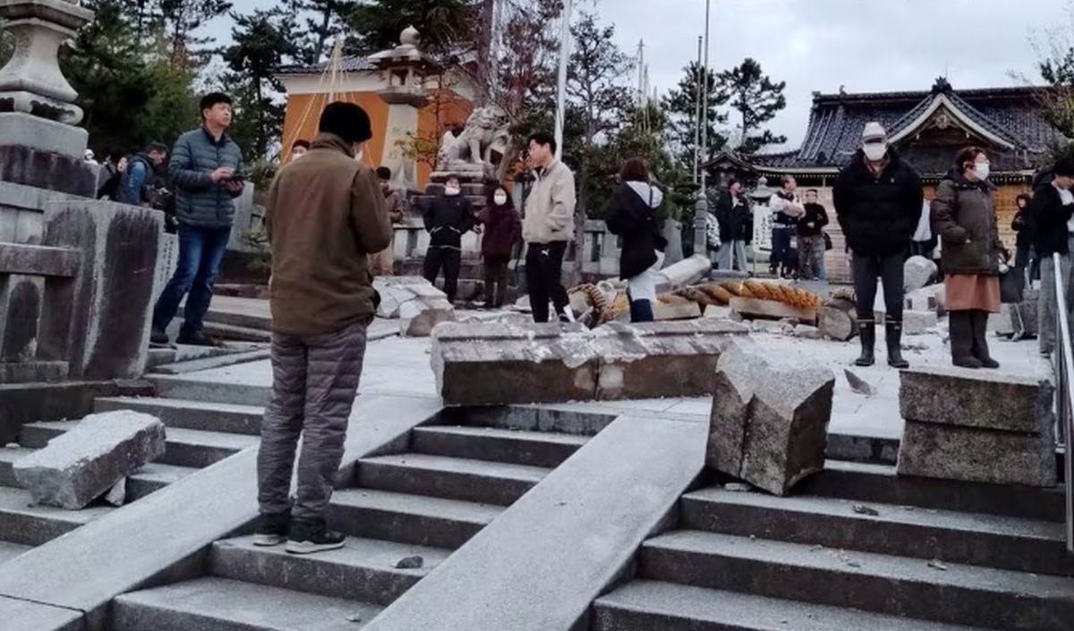 Personas paradas cerca de una puerta torii derrumbada causada por un terremoto en el Santuario Onohiyoshi en Kanazawa, prefectura de Ishikawa, Japón, el 1 de enero de 2024 | Foto: Kyodo via REUTERS