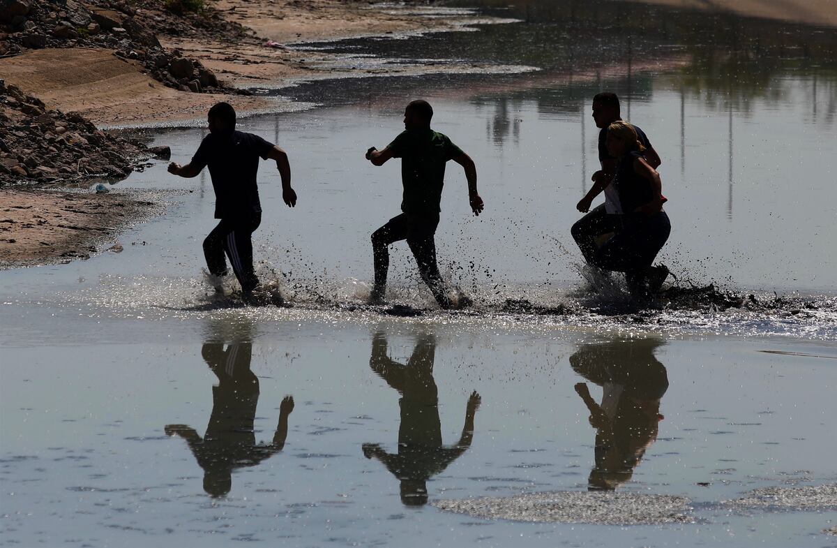 Migrantes venezolanos corren mientras cruzan el Río Bravo, o Río Grande, hacia los Estados Unidos para buscar asilo político (Foto: Herika Martínez / AFP)