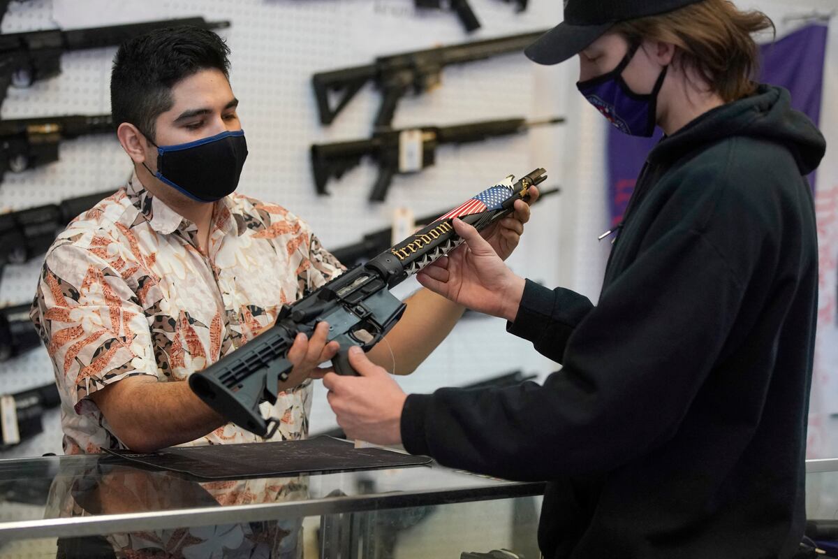 Un cliente observa un rifle de estilo AR-15 hecho a medida en Davidson Defense en Orem, Utah. (GEORGE FREY / AFP).