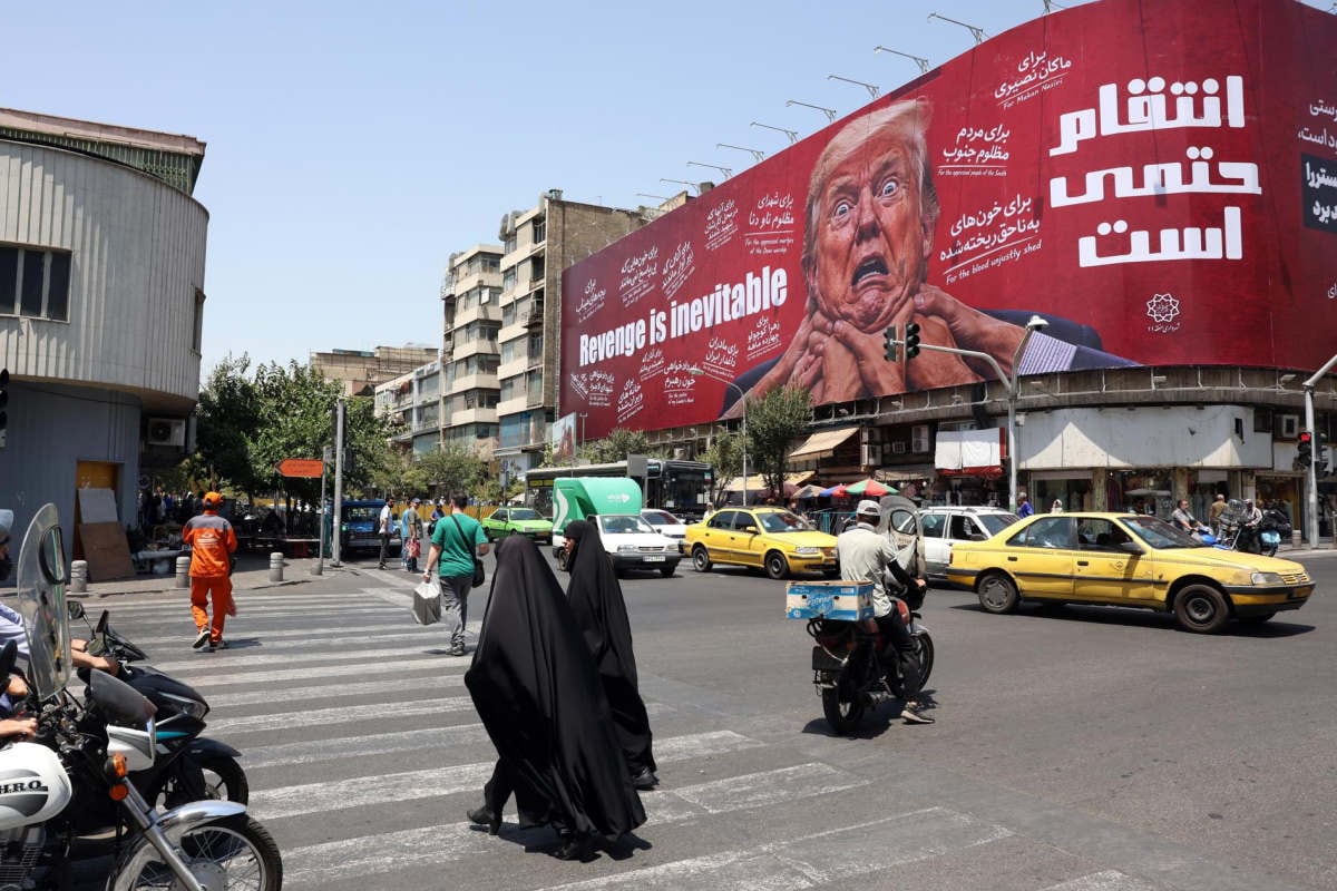 Mujeres caminan junto a una valla publicitaria antiestadounidense y anti-Trump en una calle de Teherán, Irán, el 27 de julio de 2026. Foto: EFE/EPA/ABEDIN TAHERKENAREH