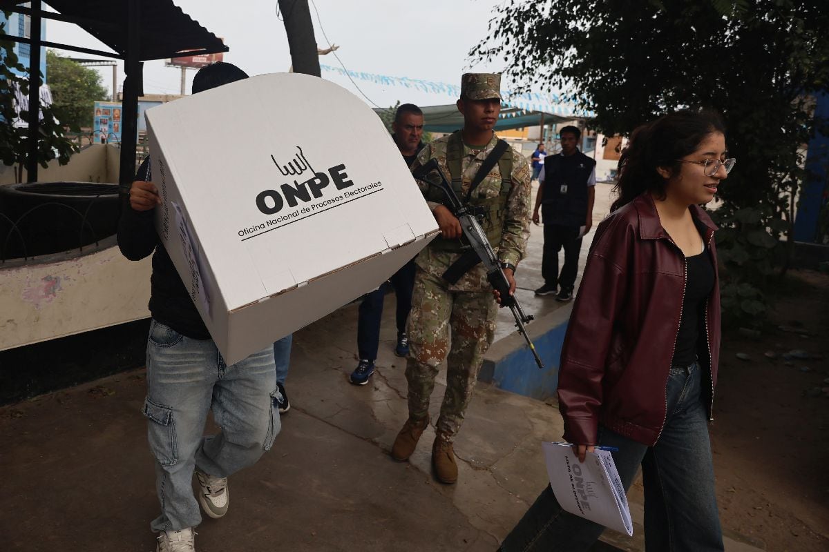 Funcionarios electorales acompañados por un miembro del ejército en un centro de votación durante la segunda vuelta de las elecciones en Lima, Perú, el 7 de junio.