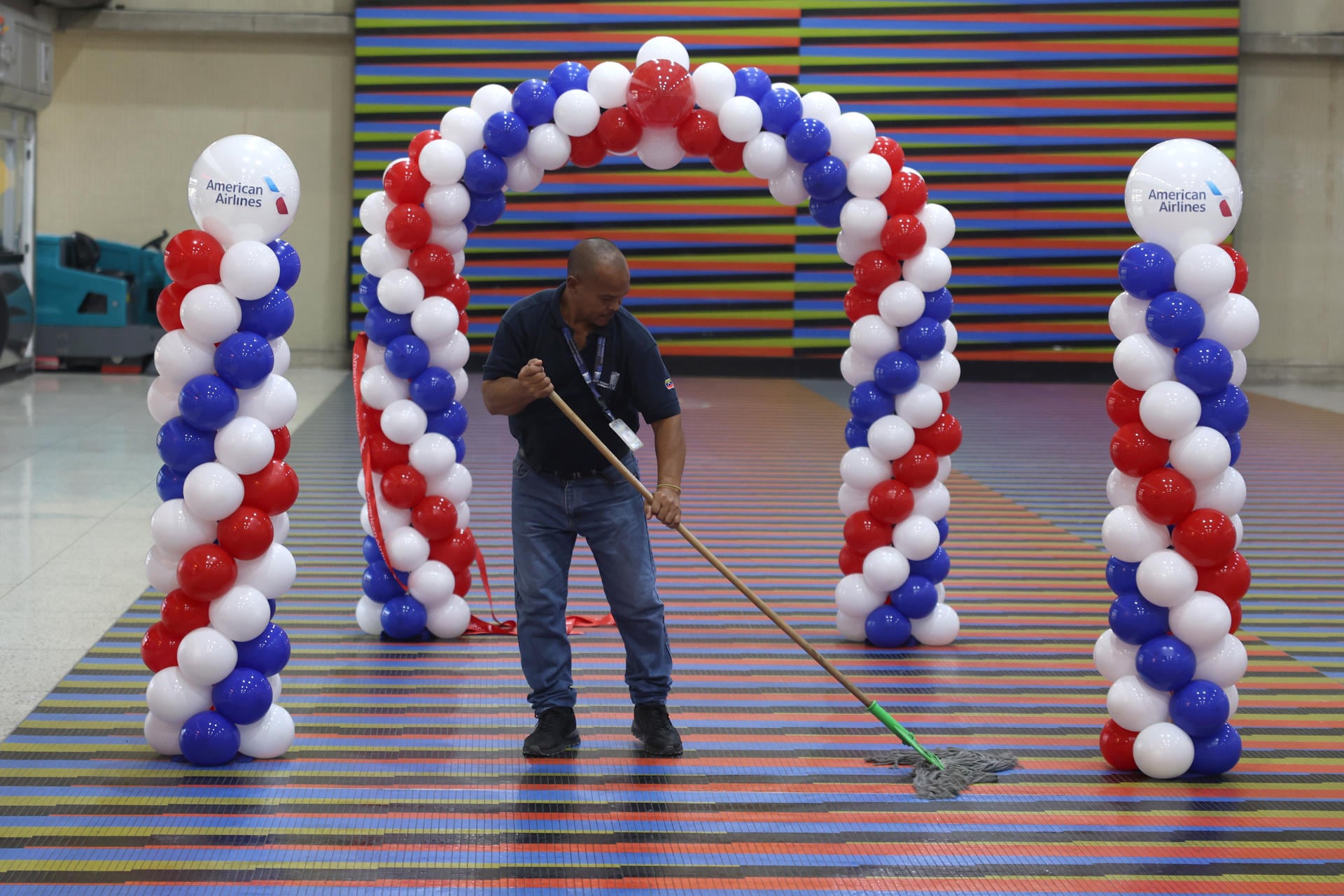 Una persona realiza labores de limpieza durante los preparativos para recibir el vuelo entre Miami y Caracas en siete años, en el Aeropuerto Internacional de Maiquetía, en Venezuela. (EFE/ Miguel Gutiérrez).
