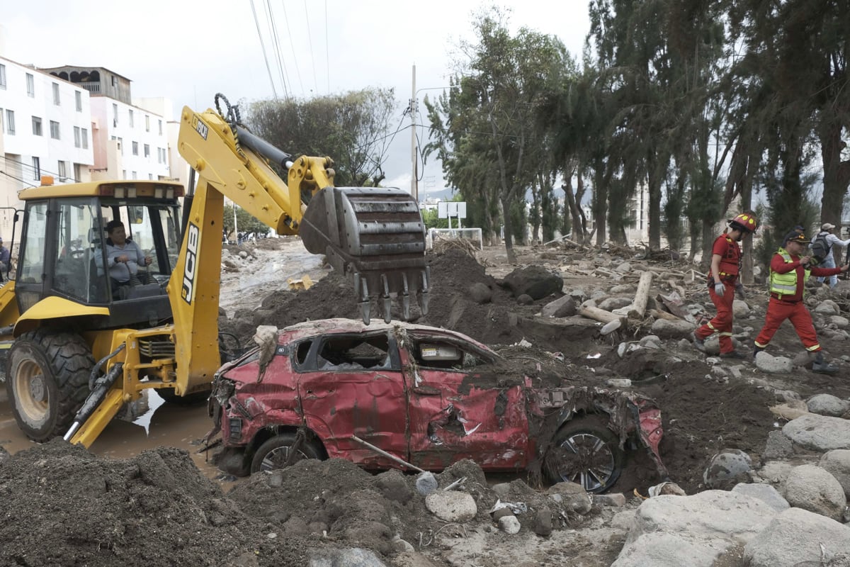 Integrantes del Cuerpo General de Bomberos Voluntarios del Perú inspeccionan una zona afectada por lluvias e inundaciones, en Arequipa, Perú, el 23 de febrero de 2026. (Oswald Charca / EFE)