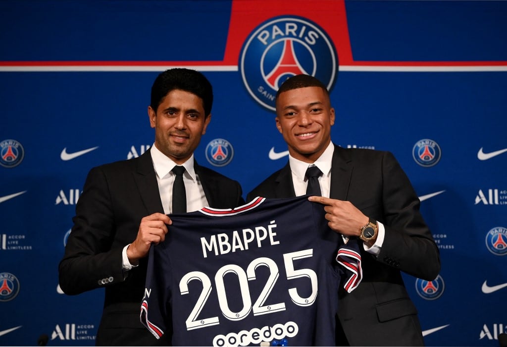 (FILES) Paris Saint-Germain's CEO Nasser Al-Khelaifi (L) and French forward Kylian Mbappe (R) pose with a jersey at the end of a press conference at the Parc des Princes stadium in Paris on May 23, 2022, two days after the club won the Ligue 1 title for a record-equalling tenth time and its superstar striker Mbappe chose to sign a new contract until 2025 at PSG rather than join Real Madrid. French football club PSG was sentenced on December 16, 2025, by a the Paris labour court to pay 59.2 million euros to French forward Kylian Mbappe in a wage dispute. (Photo by FRANCK FIFE / AFP)