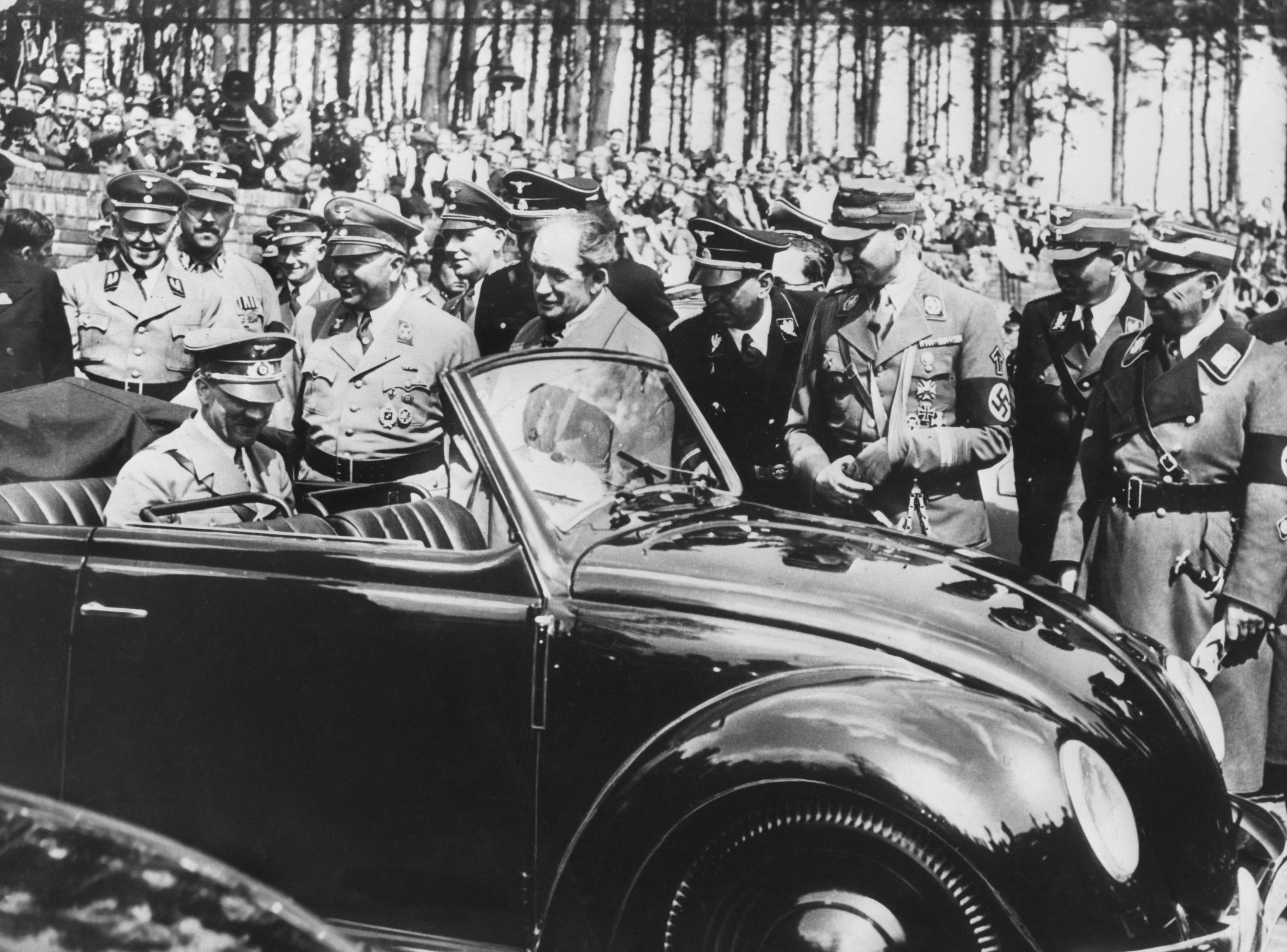 El canciller alemán Adolf Hitler (sentado en el asiento trasero) inspecciona el primer Volkswagen "Escarabajo" fabricado en Stuttgart en 1937. (Foto de AFP)