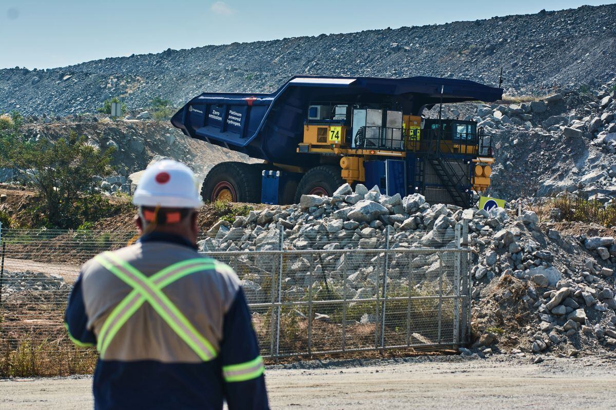 A worker watches a hydrogen-powered truck, part of Anglo American Plc's NuGen carbon-neutral project, during a moving demonstration at the Anglo American Platinum Ltd. Mogalakwena platinum mine in Mogalakwena, South Africa, on Friday, May 6, 2022. Anglo American unveiled the worlds biggest green-hydrogen powered truck at a platinum mine in northeast South Africa where it aims to replace a fleet of 40 diesel-fueled vehicles that each use about a million liters of the fossil fuel every year. Photographer: Waldo Swiegers/Bloomberg