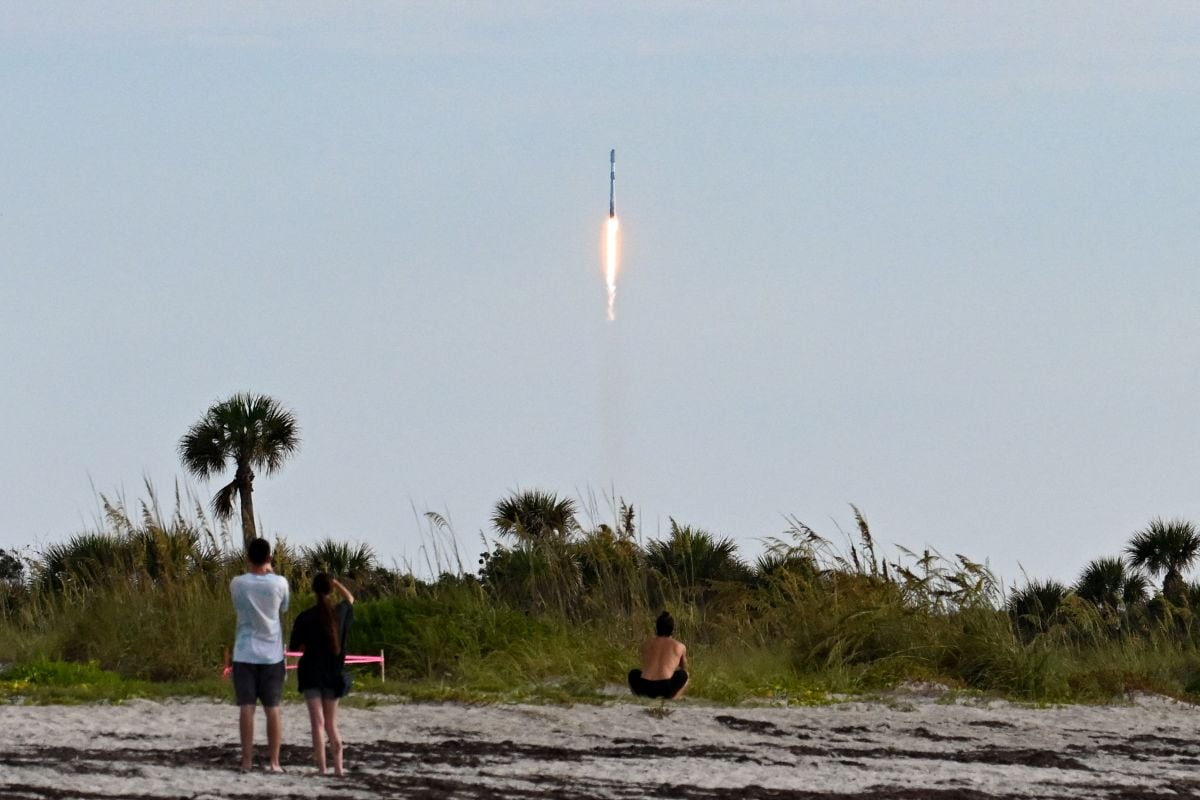 La gente observa cómo despega un cohete Falcon 9 de SpaceX, que transporta la misión Starlink 10-54, desde el Complejo de Lanzamiento Espacial 40 de la Estación de la Fuerza Espacial de Cabo Cañaveral, en Cabo Cañaveral, Florida, el 12 de junio de 2026. (Foto de CHANDAN KHANNA / AFP)
