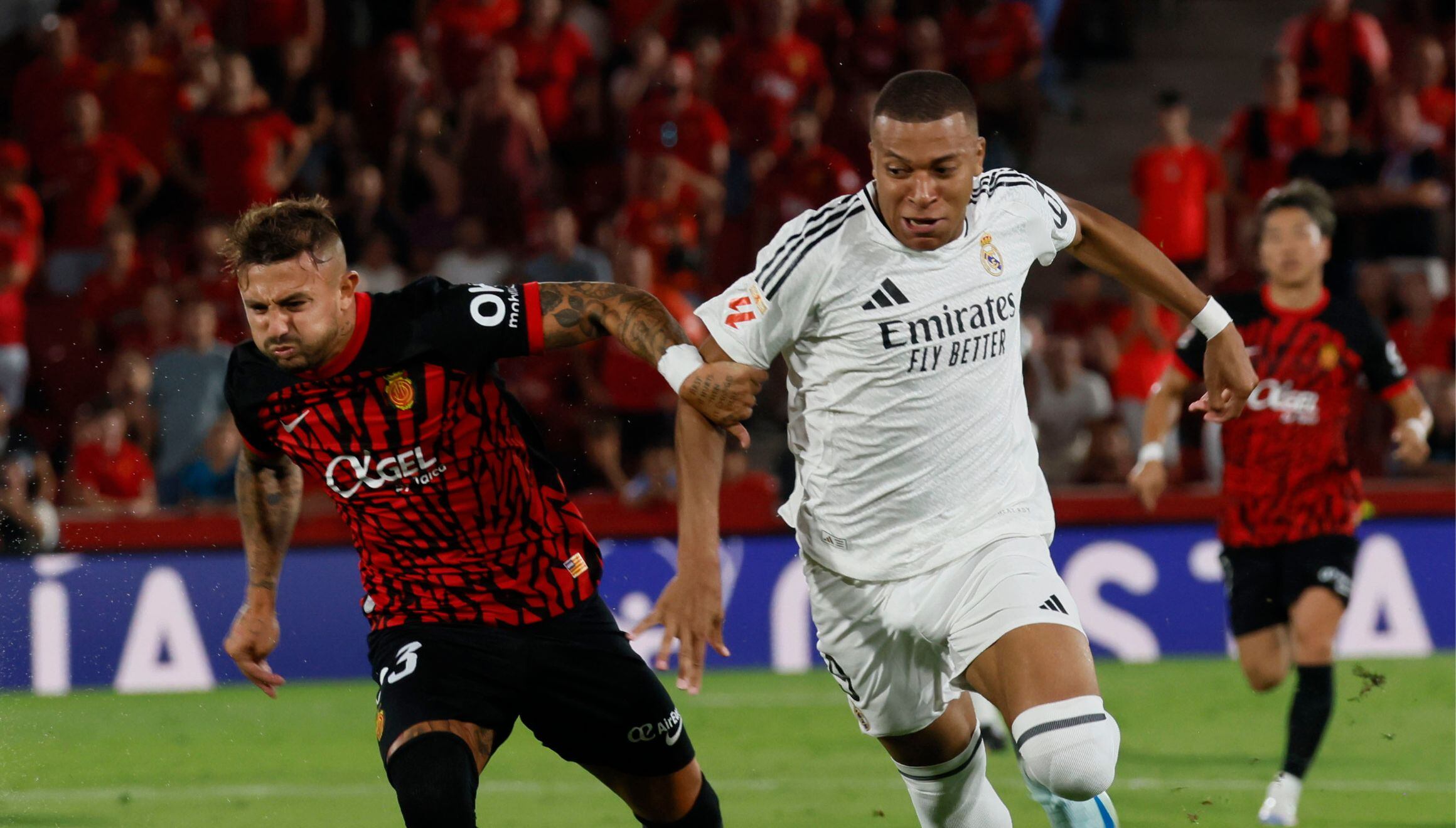 El delantero francés del Real Madrid Kylian Mbappé (der.) lucha con Pablo Maffeo, del RCD Mallorca, durante el partido de LaLiga entre el RCD Mallorca y el Real Madrid, este domingo en el estadio de Son Moix, en Palma. | Crédito: EFE / Cati Cladera