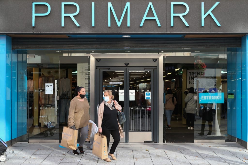 Dos clientas salen de la tienda de ropa Primark con sus compras en el centro de Cardiff el 23 de octubre de 2020. Associated British Foods anunció el 21 de abril de 2026 que escindiría su cadena de moda económica Primark, dividiendo así una de las mayores empresas de consumo del país. (Foto de Geoff Caddick / AFP)