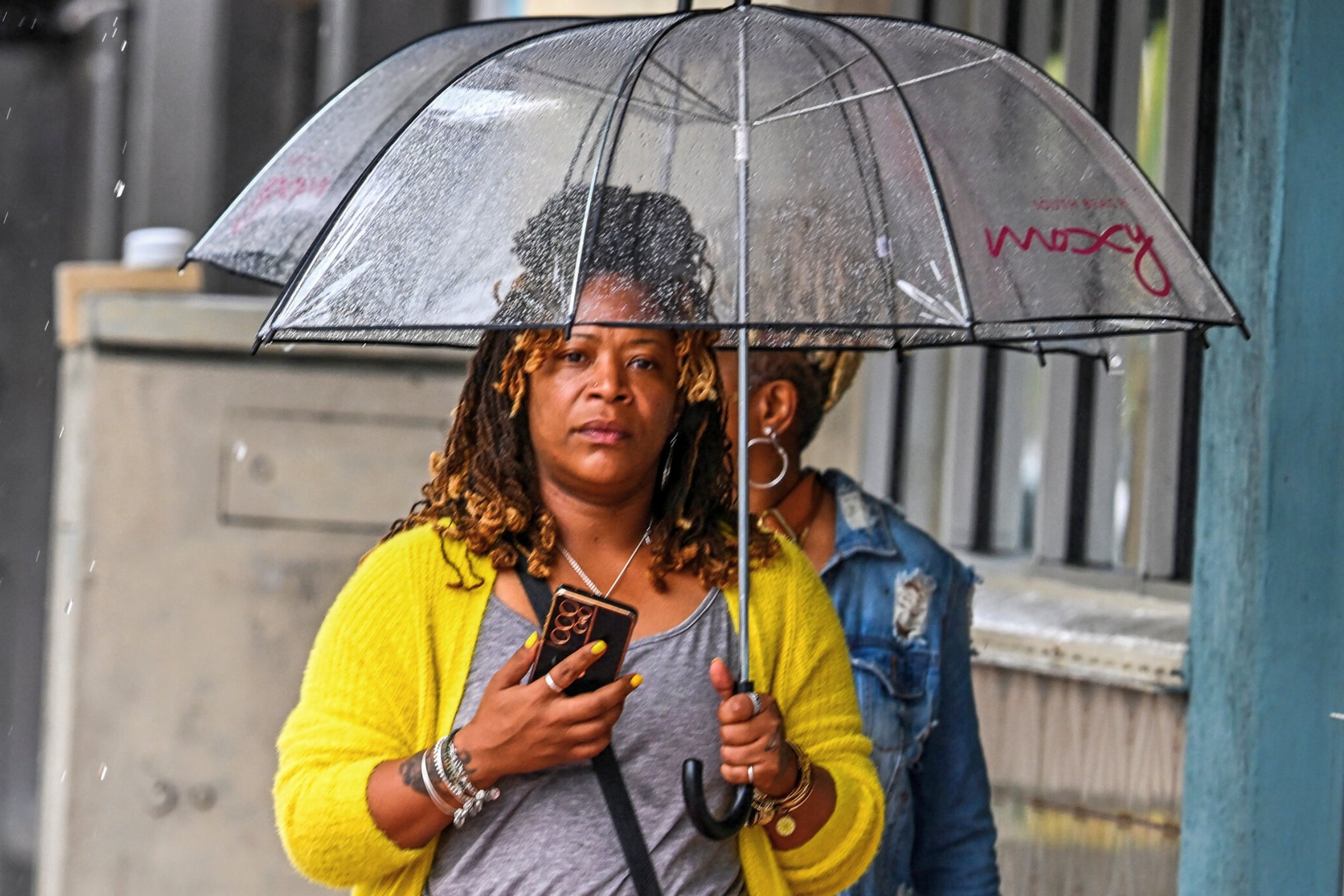 Una mujer en Florida protegiéndose de la lluvia con un paraguas (Foto: AFP)