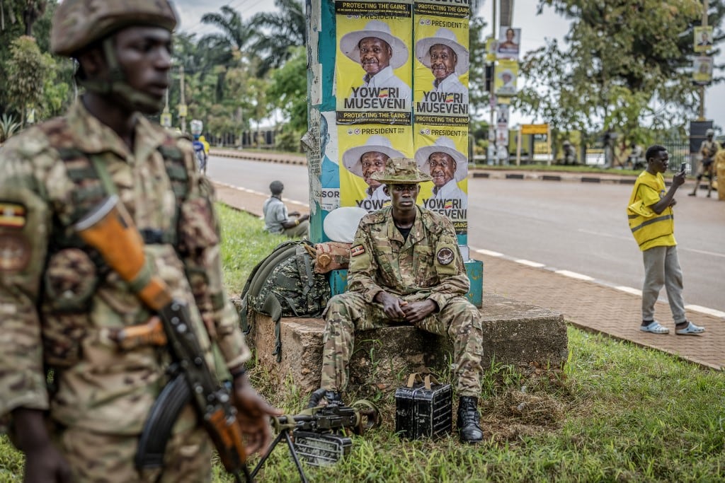 Miembros del Comando de Fuerzas Especiales de Uganda vigilan la zona mientras partidarios del presidente en ejercicio y candidato presidencial del Movimiento de Resistencia Nacional (MRN), Yoweri Museveni, se dirigen al lugar de la manifestación antes del mitin de cierre de campaña del partido para las elecciones generales ugandesas de 2026, en Kampala el 13 de enero de 2026. (Foto de AFP)