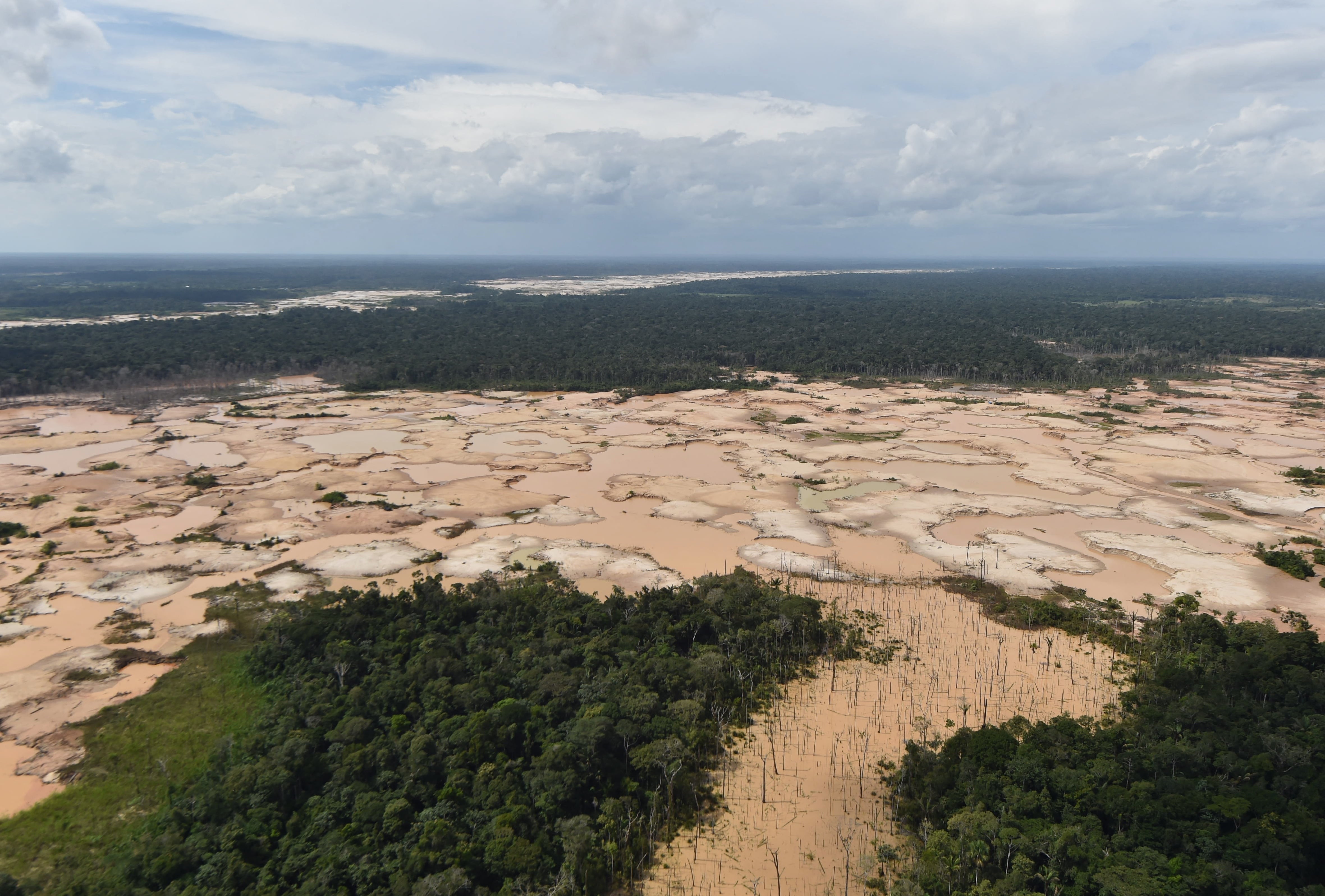 Vista aérea de una zona de la selva amazónica deforestada químicamente por actividades mineras ilegales en la cuenca del río Madre de Dios, en el sureste de Perú, durante la operación conjunta 'Mercurio' de militares y policías peruanos el 19 de febrero de 2019. (Foto de CRIS BOURONCLE / AFP)