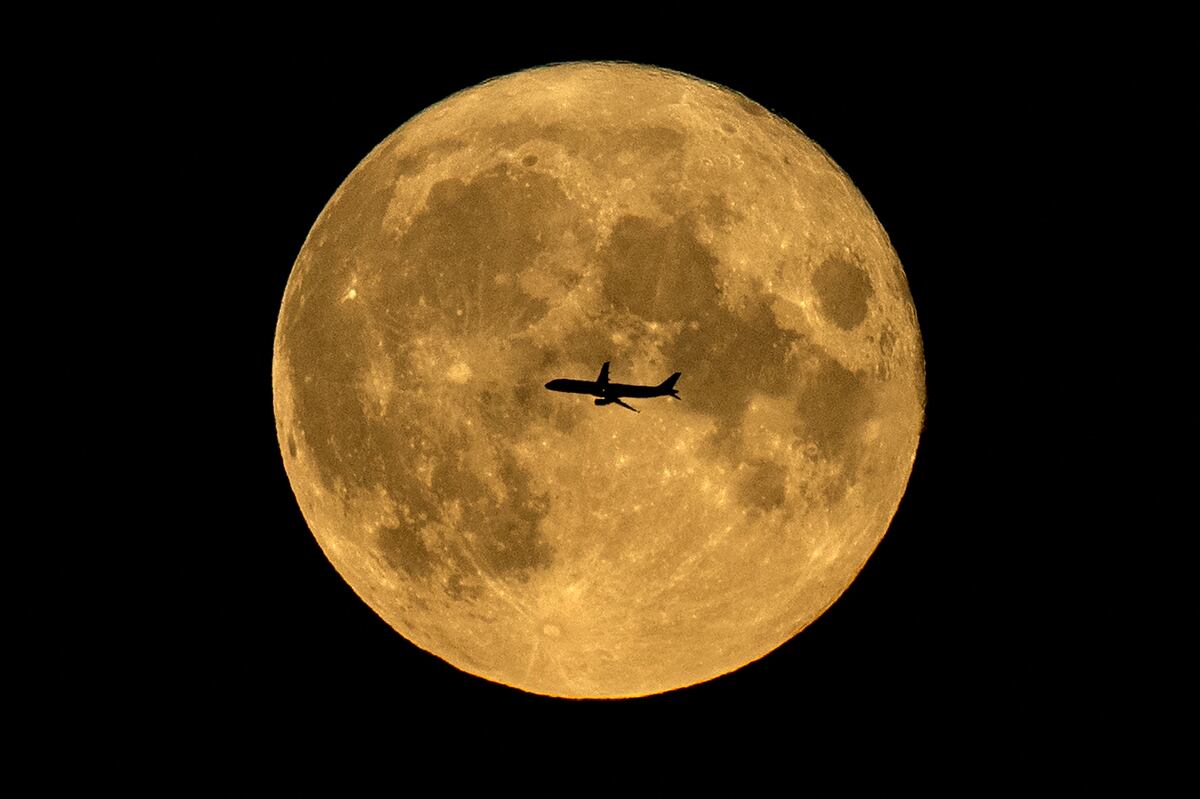 La silueta de un avión contra la luna llena en Moscú, el 22 de agosto de 2021 (Foto: AFP)