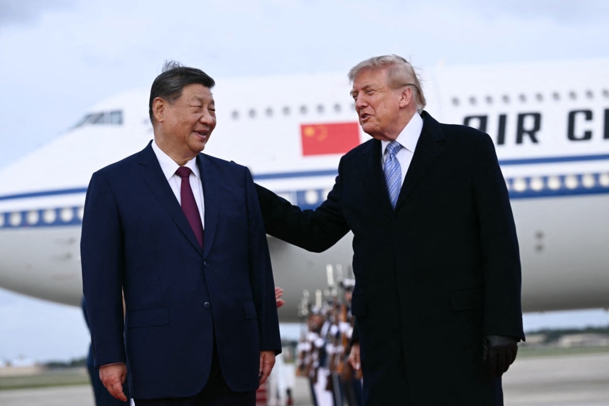 El presidente de Estados Unidos, Donald Trump, estrechó la mano de Xi Jinping el miércoles al ofrecer al líder chino una inusual bienvenida personal en el aeropuerto, al inicio de una visita de Estado de tres días. (Brendan SMIALOWSKI / AFP)