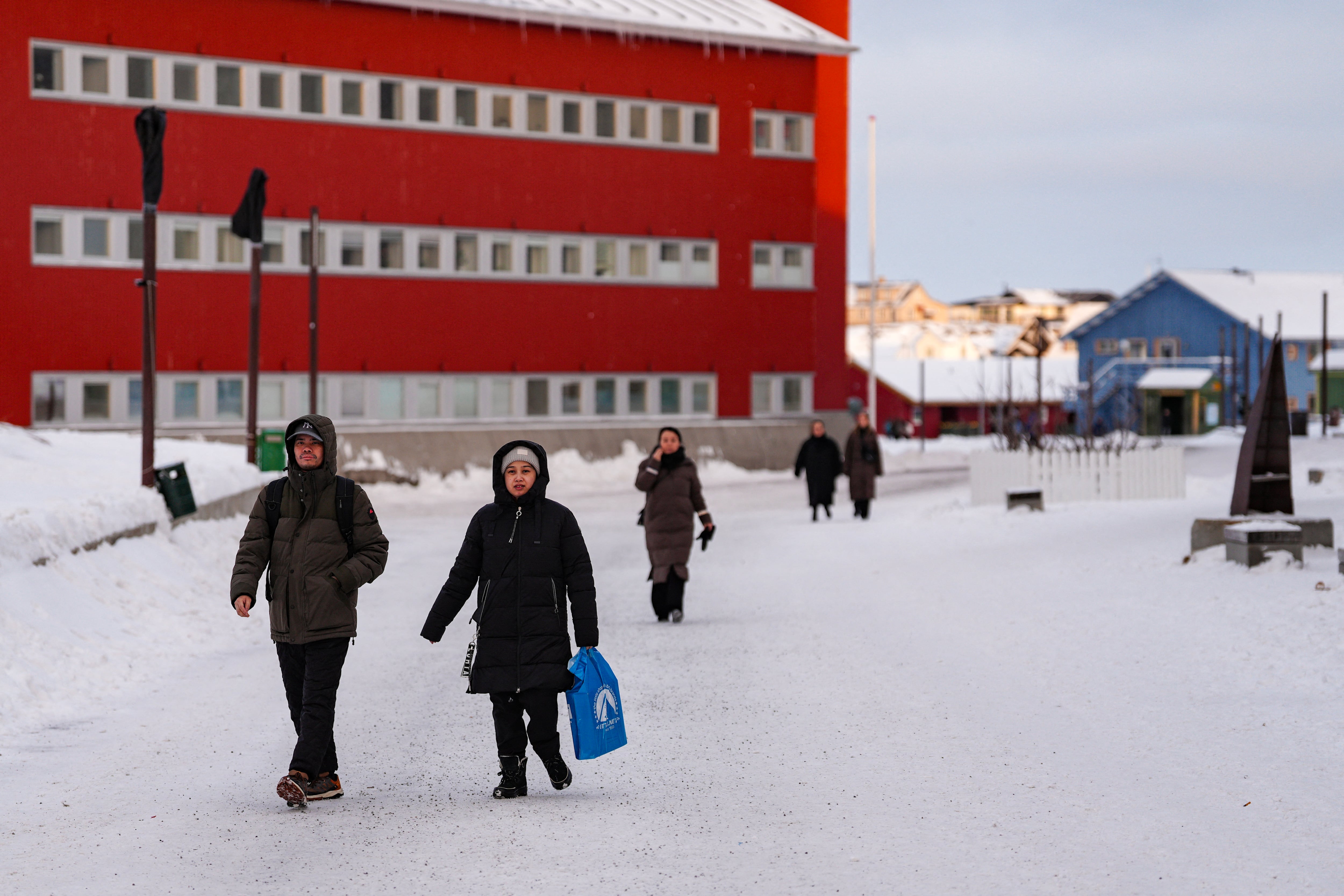Personas caminan por la principal calle comercial frente al Inatsisartut (el parlamento de Groenlandia), en Nuuk, el 15 de enero de 2026. (Foto de Alessandro Rampazzo / AFP).