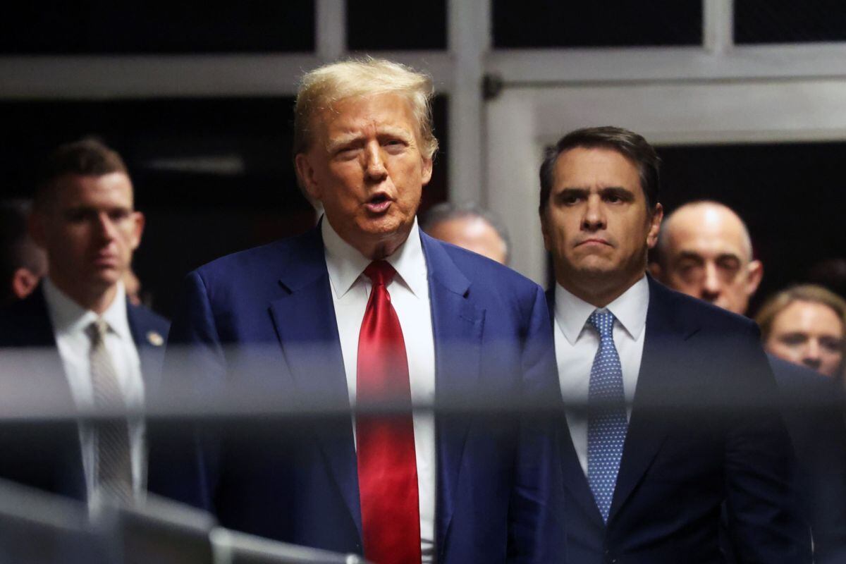 Former US President Donald Trump, center, speaks to members of the media in the hallway outside a courtroom at Manhattan criminal court in New York, US, on Monday, March 25, 2024. Trump is in court for a high-stakes hearing on his last-ditch bid to dismiss charges brought by Manhattan District Attorney Alvin Bragg, who accused Trump of falsifying business records to disguise hush money payments to a porn star before the 2016 election.