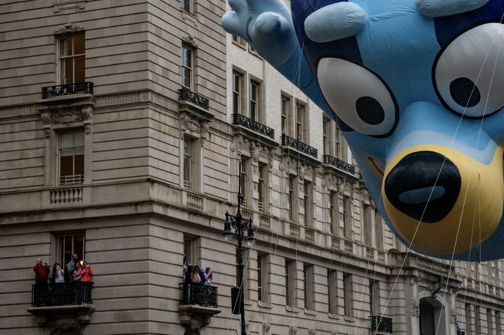 La gente observa desde los balcones cómo pasan los globos durante el desfile anual del Día de Acción de Gracias de Macy's en la ciudad de Nueva York el 28 de noviembre de 2024. Foto: David Dee Delgado / AFP